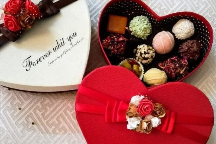 Luxury dark chocolates in brown gift box with gold ribbon
