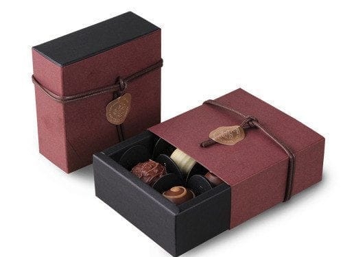 Black graduation-themed chocolate box with gold cap topper