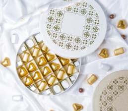 top view of round chocolate box with golden and silver wrapped chocolates 27 top view round chocolate box with golden silver wrapped chocolates scaled uai top view of round chocolate box with golden and silver wrapped chocolates